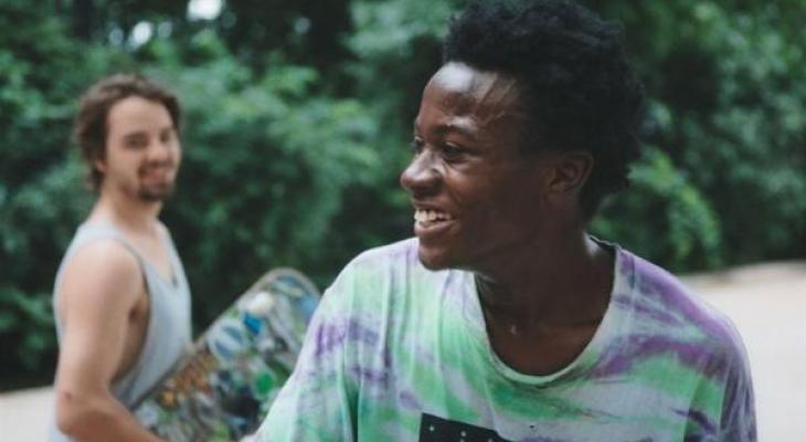 Two young men outside smiling