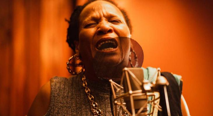 A woman sings into a microphone.