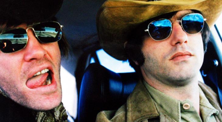 Two band members in sunglasses and cowboy hats gaze at the camera with rock'n'roll attitude.