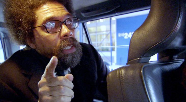 a man with a beard and glasses in the back of a car