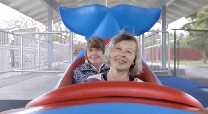 two women on a fish shaped carnival ride