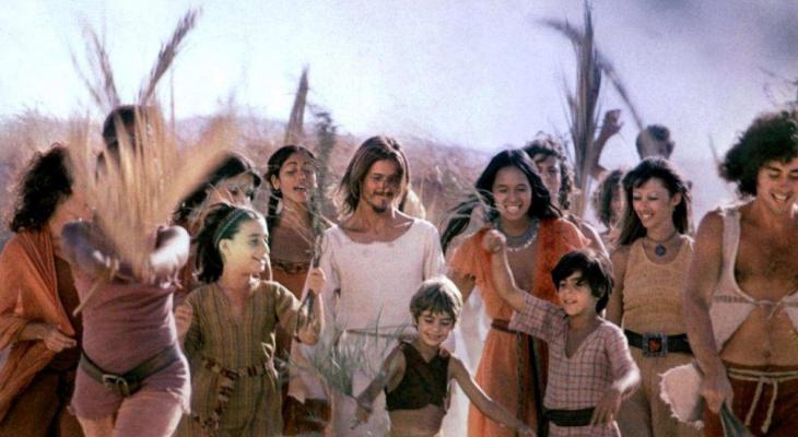 Jesus Christ and his followers walk through a field.