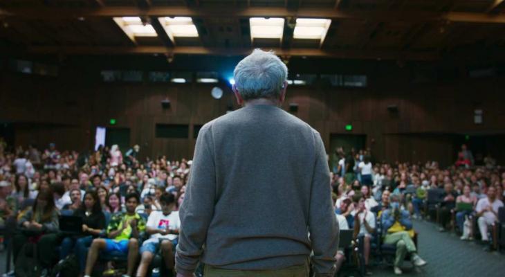 a man speaking to an auditorium full of students
