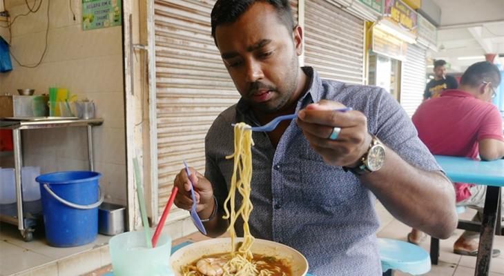 Suresh Doss eating a bowl of noodles at a restaurant