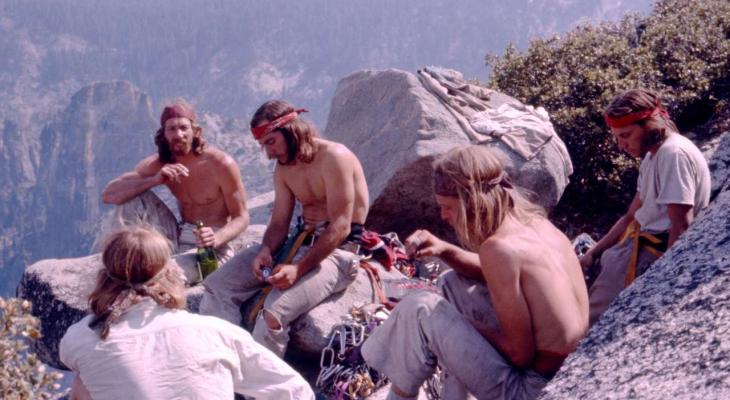 Climbers rest at the top of a rockface.