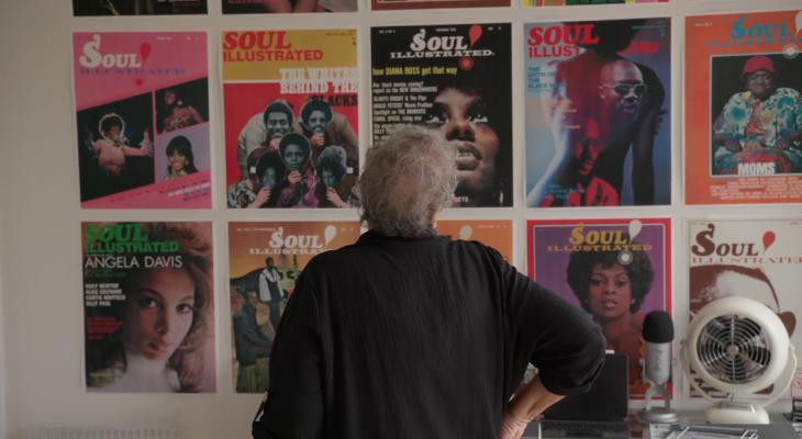 Regina Jones examines covers of Soul magazine mounted on a wall.