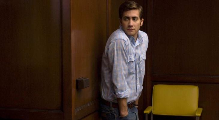 a man looking over his shoulder next to a chair