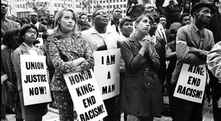 young diverse people hold protest signs against racism