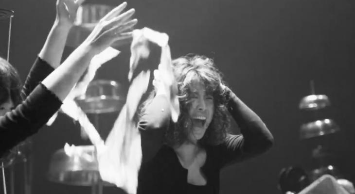 This is a black and white picture, and the person in the picture is raising both hands, immersed in the music.