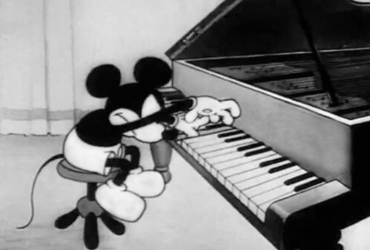 It's a black and white picture of Mickey Mouse playing the piano