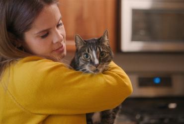 A woman holds a housecat.