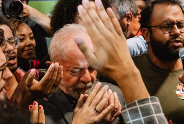 a man praying while surround by people