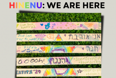a park bench with all of the slats decorated with rainbows and hebrew and various designs and the words "hinenu: we are here" written above it