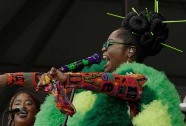 A singer performs in a bright green tulle costume. 