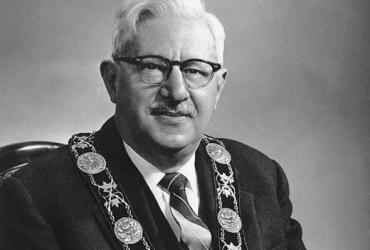 man wearing glasses and mayor's necklace
