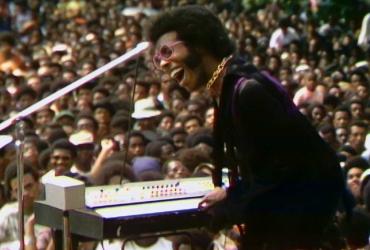 A man performs onstage in front of a large crowd.