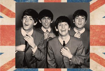 Black and white photo of the beatles, with border of the British flag