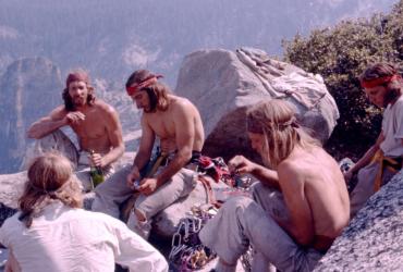 Climbers rest at the top of a rockface.