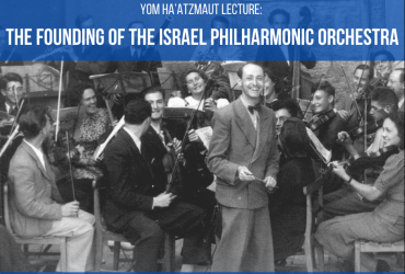 Black and white photograph of the Israel Philharmonic Orchestra. The conductor is smiling brightly while the orchestra members are seated with instruments in hand.