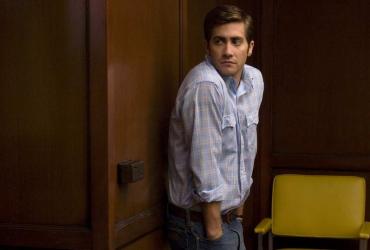 a man looking over his shoulder next to a chair