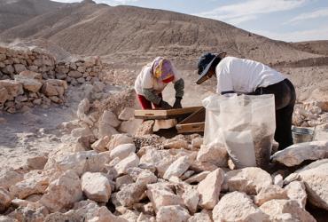 Two archaeologists digging in the field