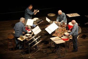 Four members of NEXUS perform on a stage with percussion instruments.